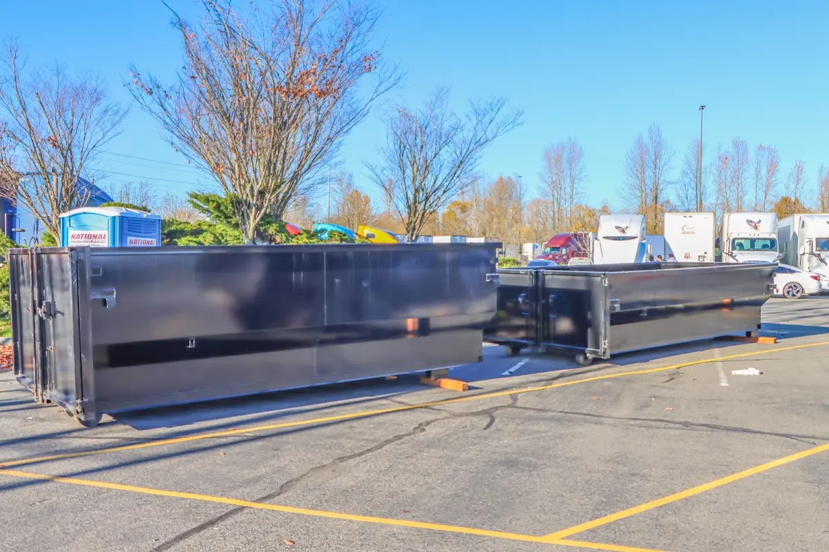 Professional dumpster rental service with roll-off container on residential driveway in Friendly